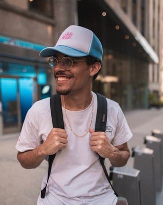 man in white crew neck t-shirt wearing blue cap and black sunglasses