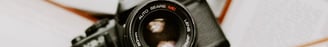 black nikon dslr camera on white printer paper