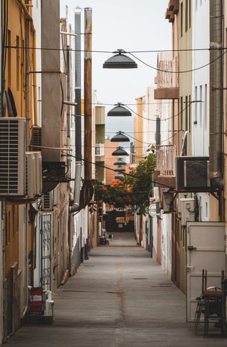 empty hallway between concrete buildings during daytime