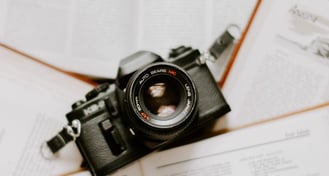 black nikon dslr camera on white printer paper