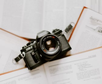 black nikon dslr camera on white printer paper