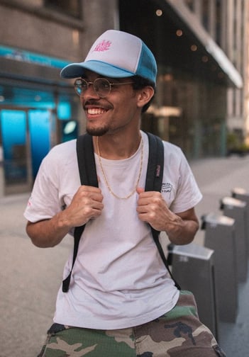 man in white crew neck t-shirt wearing blue cap and black sunglasses