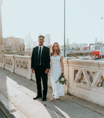 man in black suit standing beside woman in white wedding dress