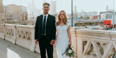 man in black suit standing beside woman in white wedding dress