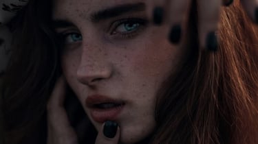 woman with brown hair wearing white and black floral hijab