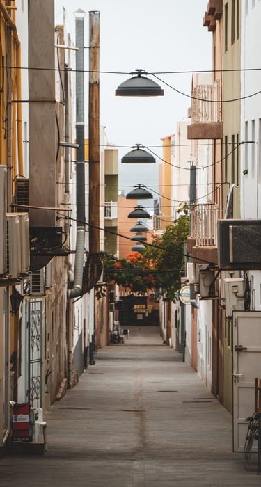 empty hallway between concrete buildings during daytime