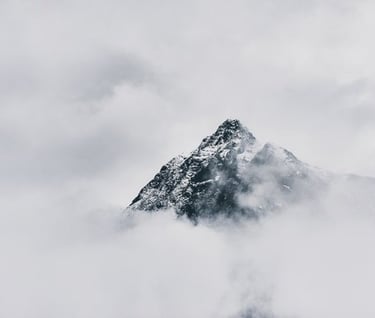 snow covered mountain under cloudy sky during daytime