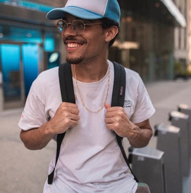 man in white crew neck t-shirt wearing blue cap and black sunglasses
