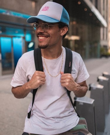man in white crew neck t-shirt wearing blue cap and black sunglasses