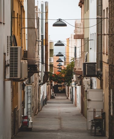 empty hallway between concrete buildings during daytime