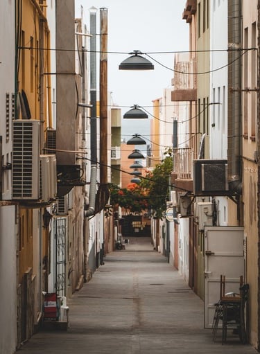 empty hallway between concrete buildings during daytime