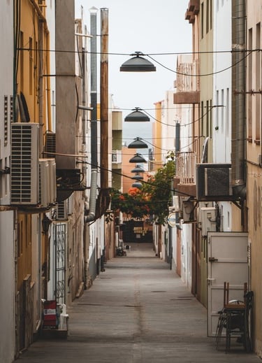 empty hallway between concrete buildings during daytime