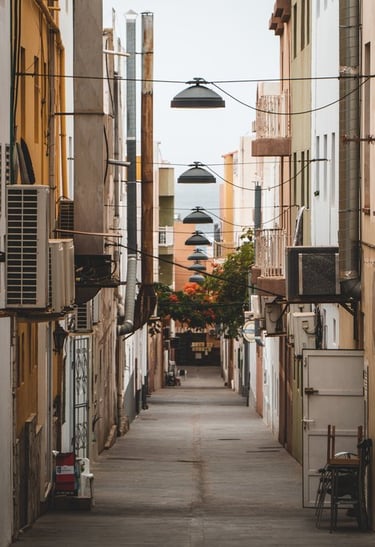 empty hallway between concrete buildings during daytime