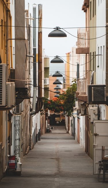 empty hallway between concrete buildings during daytime