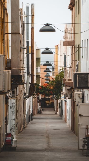 empty hallway between concrete buildings during daytime