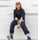 woman in black long sleeve shirt and blue denim jeans sitting on white concrete wall