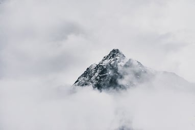 snow covered mountain under cloudy sky during daytime