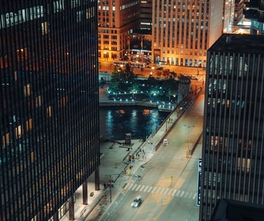 body of water between high rise buildings during night time