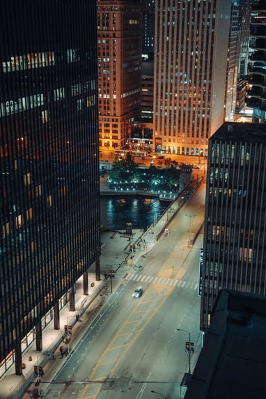 body of water between high rise buildings during night time