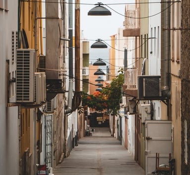 empty hallway between concrete buildings during daytime