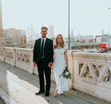 man in black suit standing beside woman in white wedding dress