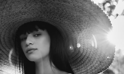 woman in white crew neck shirt wearing brown sun hat