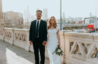 man in black suit standing beside woman in white wedding dress
