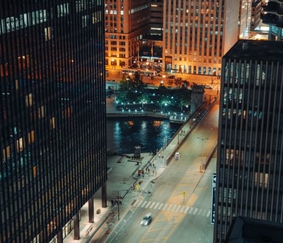 body of water between high rise buildings during night time