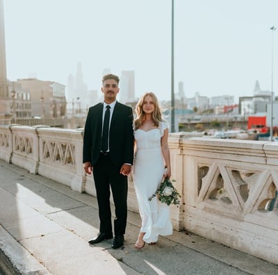 man in black suit standing beside woman in white wedding dress