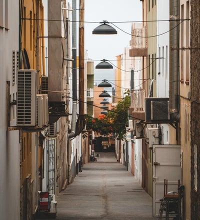 empty hallway between concrete buildings during daytime