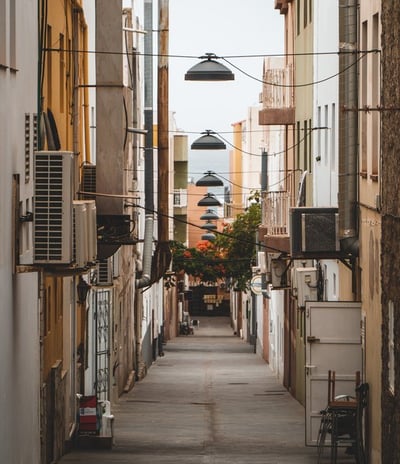 empty hallway between concrete buildings during daytime