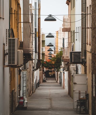 empty hallway between concrete buildings during daytime
