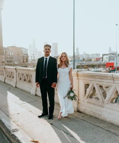 man in black suit standing beside woman in white wedding dress