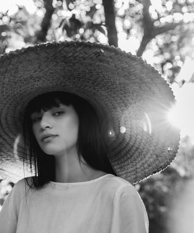 woman in white crew neck shirt wearing brown sun hat