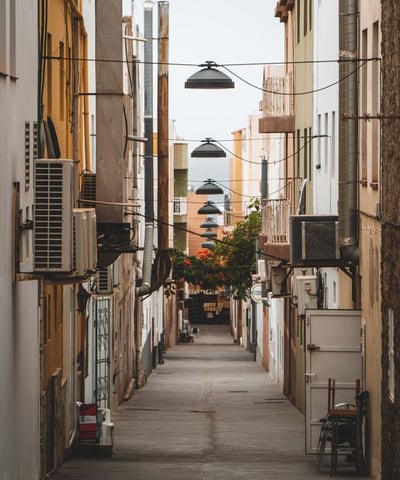 empty hallway between concrete buildings during daytime