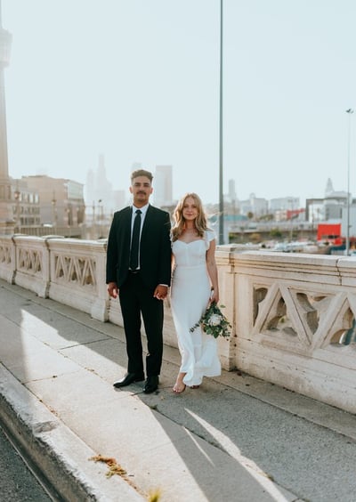 man in black suit standing beside woman in white wedding dress