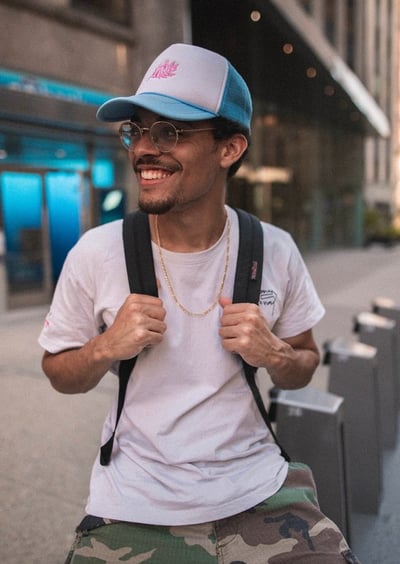 man in white crew neck t-shirt wearing blue cap and black sunglasses