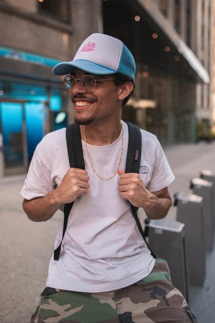 man in white crew neck t-shirt wearing blue cap and black sunglasses