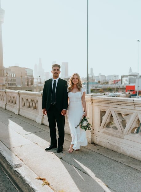 man in black suit standing beside woman in white wedding dress