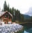 brown wooden house near lake surrounded by green trees during daytime