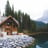 brown wooden house near lake surrounded by green trees during daytime