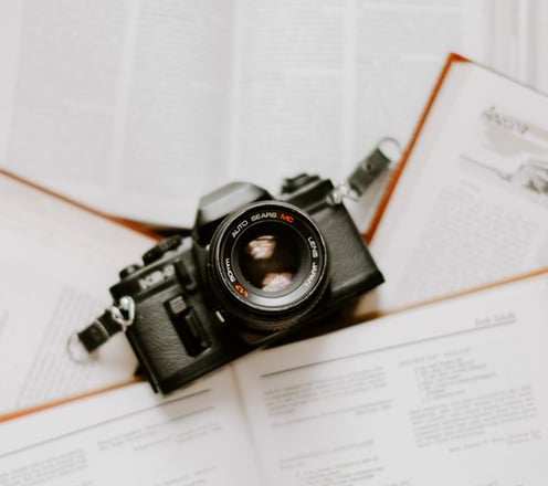 black nikon dslr camera on white printer paper