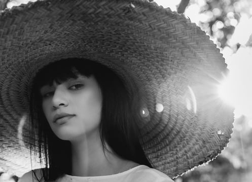 woman in white crew neck shirt wearing brown sun hat