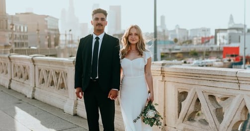 man in black suit standing beside woman in white wedding dress