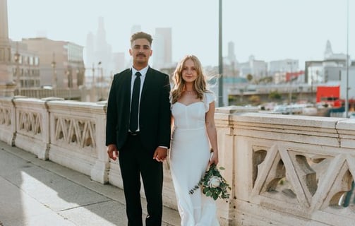 man in black suit standing beside woman in white wedding dress