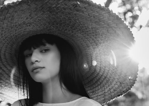 woman in white crew neck shirt wearing brown sun hat