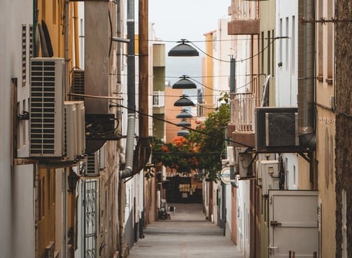 empty hallway between concrete buildings during daytime