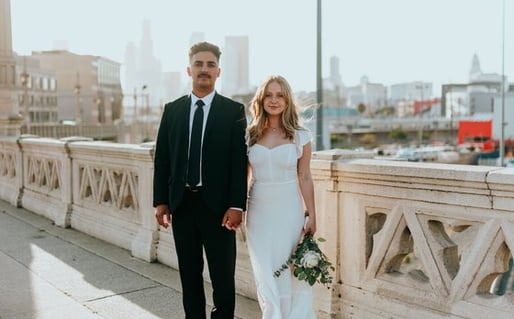 man in black suit standing beside woman in white wedding dress