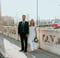 man in black suit standing beside woman in white wedding dress
