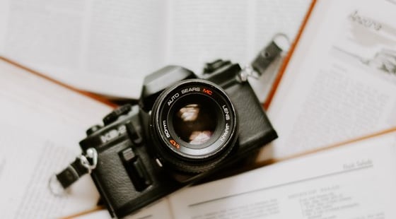 black nikon dslr camera on white printer paper